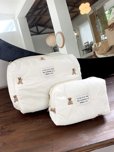 Detailed close-up of quilted cosmetic bags featuring cute brown bear embroidery set
