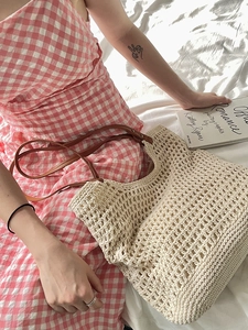 Detail of hollow woven cream crochet tote bag with brown leather handles and rivets