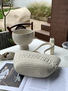 Close-up of cream woven cotton tote bag with intricate textured wave patterns