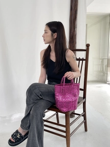Detailed texture of fuchsia metallic woven handbag styled with casual summer outfit
