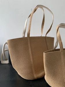 Straw woven tote bag set in natural material with long handles for beach or casual use