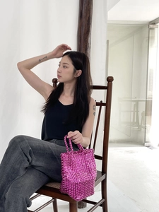 Detail of vibrant magenta woven tote bag featuring a metallic luster and handmade texture