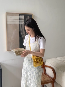 Detail of ginger yellow hand-crocheted crossbody bag showing intricate hollow weave texture