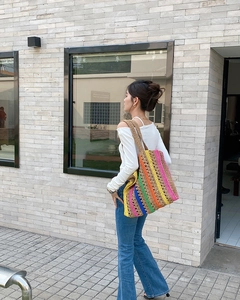 Detail of multi-color striped handmade crochet straw tote bag with shoulder straps