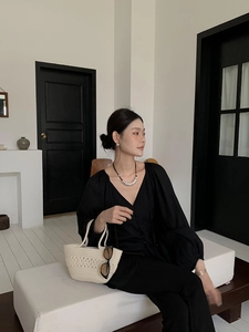 Lifestyle shot of an off-white cotton rope woven handbag with sunglasses on a model