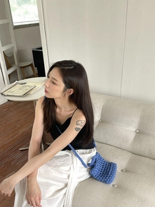 Blue hand-woven crochet bucket bag with textured pattern shown on a female model