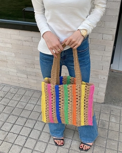 Detailed close-up of the rainbow striped straw tote bag showing woven texture and colors