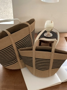 Detailed view of two striped straw tote bags set in a cozy bohemian interior scene