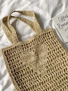 Détail de la texture en maille ajourée d'un sac cabas en raphia beige fait main