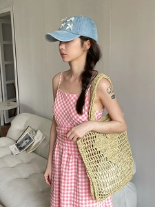 Sac fourre-tout en paille avec casquette en jean et robe à carreaux rose pour l'été
