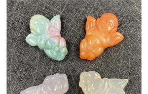 Detailed view of four colorful carved agate angel pendants with translucent textures