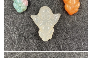 Detailed view of three carved agate angel pendants in white, green, and orange stones