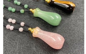 Dettaglio di collane porta profumo in quarzo rosa e avventurina con cordini intrecciati a mano