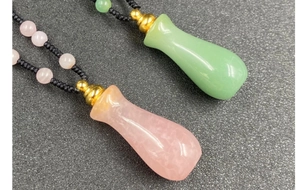 Dettaglio dei ciondoli a bottiglia in quarzo rosa e pietra verde su cordini neri