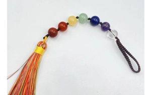Détail d'ornement aux 7 pierres de chakra avec pompons colorés tissés à la main