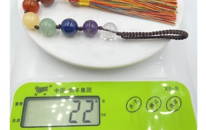 Détail d'un pendentif de voiture en pierres naturelles pesant 22g sur une balance digitale