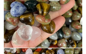 Close-up of polished heart-shaped natural crystals including rose quartz and tiger eye