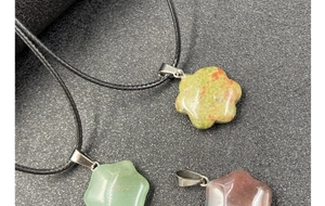 Detailed view of flower-shaped natural stone pendants with woven cords and steel clasps