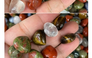 Hand holding heart shaped natural crystal stones showing scale and smooth finish