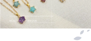 Detailed flat lay of star-shaped pendants featuring colorful semi-precious gemstones on gold chains
