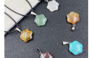 Flat lay of star-shaped obsidian and quartz crystal pendants with natural stone textures