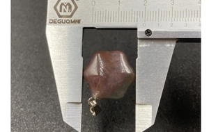 Detailed measurement of red agate star pendant showing 1.8cm diameter with digital calipers