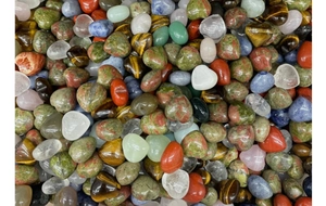 Macro shot of assorted heart-shaped natural gemstones including rose quartz and tiger eye