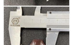 Detail view showing 25mm measurement of translucent reddish-brown gemstone pendant