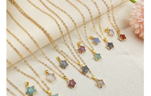 Detail of star-shaped crystal pendants in various colors on golden link chains