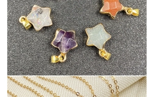 Macro detail of star-shaped natural crystal pendants with gold metal clasp on O-chain