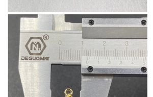 Detailed measurement of gold star pendant width showing 10.5mm on a vernier caliper