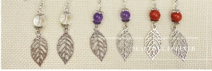 Detail of forest style leaf earrings with colorful beads and silver metal pendants