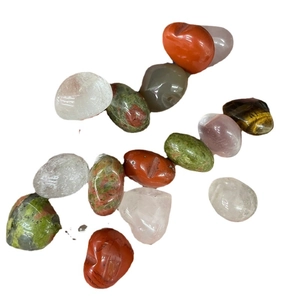 Polished natural crystal stones set including rose quartz and tiger eye on white background