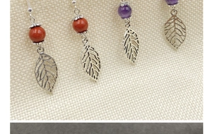 Macro detail of leaf drop earrings with colorful agate beads and silver hooks