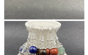 Detail view of colorful natural stone bead earrings on a white ceramic display