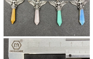 Macro view of gothic skull wing pendants with crystal stones and size measurement