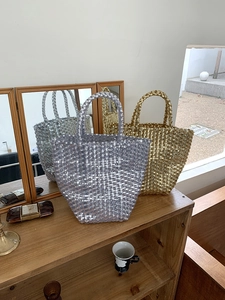 Detailed view of woven bucket bags in metallic silver and gold with checkered texture