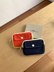 Detailed view of color-block canvas mini pouches with zipper and button pockets