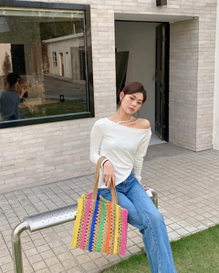 Close-up of colorful handmade crochet tote bag with striped pattern and woven texture