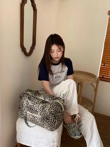 Close-up of leopard print canvas tote bag featuring front zipper pocket and sturdy handles