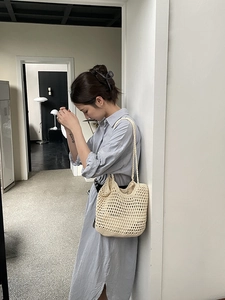 Detail of handmade hollow crochet cotton shoulder bag with beige woven mesh texture
