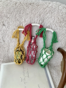 Détail de trois supports colorés en corde de coton tissée main avec poignées renforcées