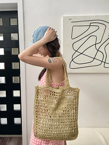Détail du tissage en maille ajourée d'un sac cabas en paille naturelle avec anses