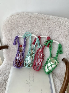 Détail de porte-bouteilles en macramé tissé à la main avec franges sur la poignée