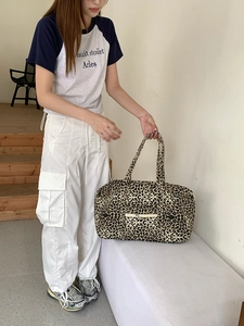 Detailed view of leopard print canvas tote with external zipper pocket and large capacity