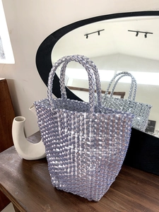 Detailed close-up of the translucent purple woven plastic basket bag and sturdy handles