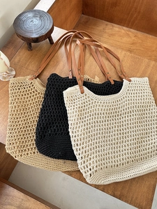 Detailed close-up of three woven tote bags with leather straps on a dark wooden table