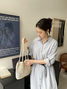 Detailed close-up of a beige handmade crochet woven tote bag with hollow-out pattern