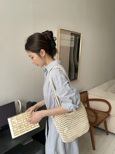 Detail of hand-woven hollow mesh cotton shoulder bag in cream white minimalist style