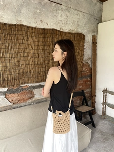 Detailed close-up of a handmade crochet crossbody bag with woven hollow-out mesh texture